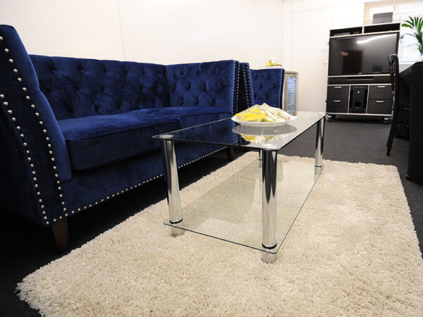 blue marlborough sofa and armchair in a backstage room, with two tier coffee table and entertainment hub