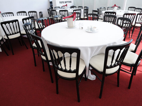 black napoleon chairs set around round dining tables