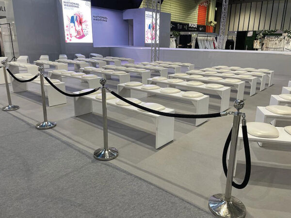 white seminar benches with white faux leather seat pads at national wedding show