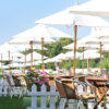 wicker cafe chairs and hardwood round tables with parasols