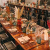 enamor copper cutlery on vintage trestle table, invitation glassware and gun metal tolix chairs