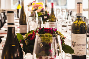 wine glasses and wine bottles on a long table